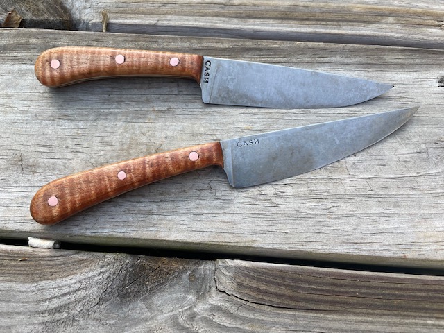 a knife sitting on top of a wooden cutting board